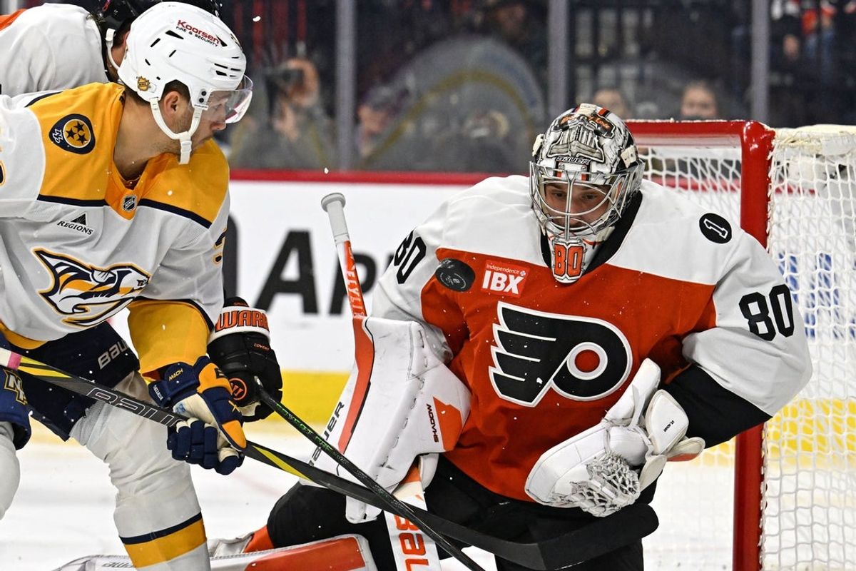 Oct 30, 2025; Philadelphia, Pennsylvania, USA; Philadelphia Flyers goaltender Dan Vladar (80) makes a save as Nashville Predators left wing Michael Bunting (58) looks on during the second period at Xfinity Mobile Arena. Mandatory Credit: Eric Hartline-Imagn Images