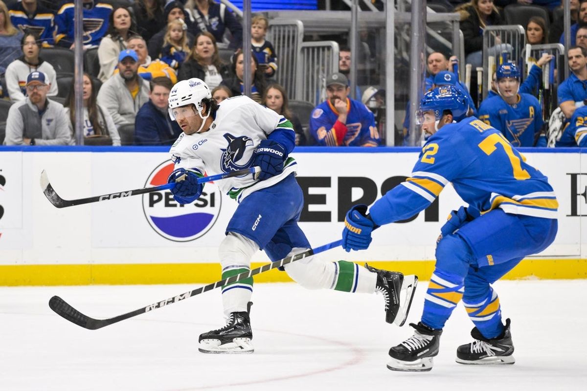 Oct 30, 2025; St. Louis, Missouri, USA; Vancouver Canucks left wing Kiefer Sherwood (44) shoots as St. Louis Blues defenseman Justin Faulk (72) defends during the first period at Enterprise Center. Mandatory Credit: Jeff Curry-Imagn Images
