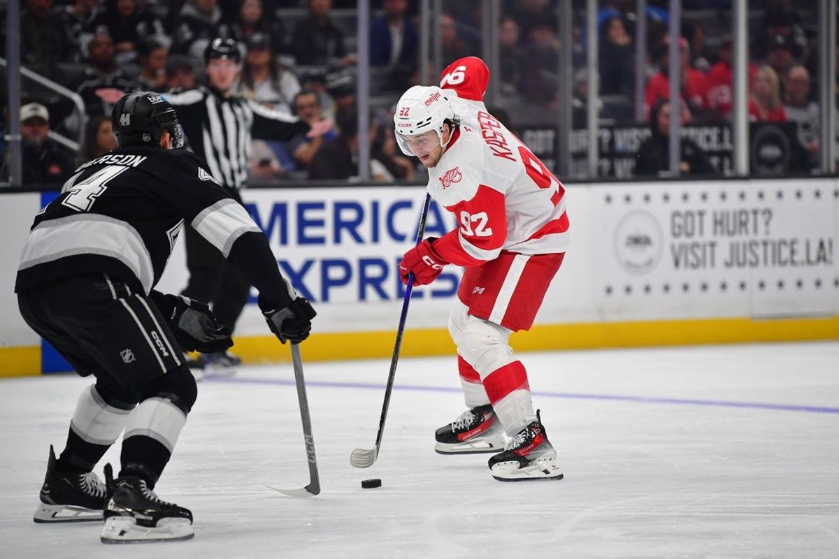 Oct 30, 2025; Los Angeles, California, USA; Detroit Red Wings center Marco Kasper (92) moves the puck against Los Angeles Kings defenseman Mikey Anderson (44) during the third period at Crypto.com Arena. Mandatory Credit: Gary A. Vasquez-Imagn Images