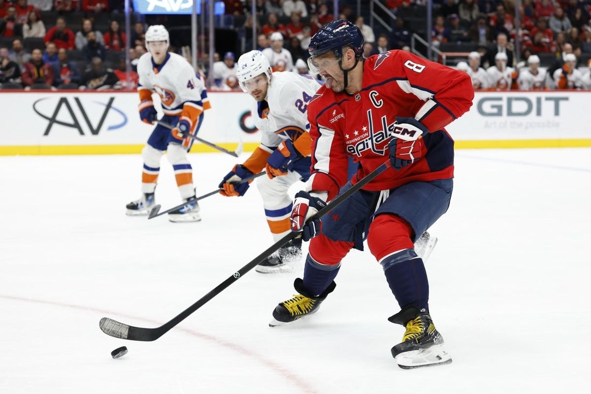 Oct 31, 2025; Washington, District of Columbia, USA; Washington Capitals left wing Alex Ovechkin (8) skates with the puck against as New York Islanders defenseman Scott Mayfield (24) chats during the first period at Capital One Arena. Mandatory Credit: Geoff Burke-Imagn Images