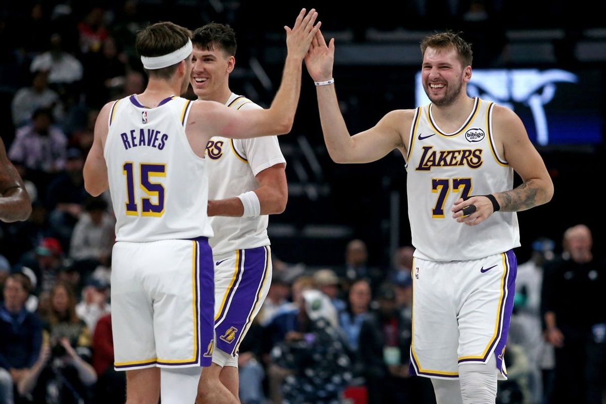 Oct 31, 2025; Memphis, Tennessee, USA; Los Angeles Lakers guard Luka Doncic (77) reacts with guard Austin Reaves (15) during a timeout during the second quarter against the Memphis Grizzlies at FedExForum. Mandatory Credit: Petre Thomas-Imagn Images