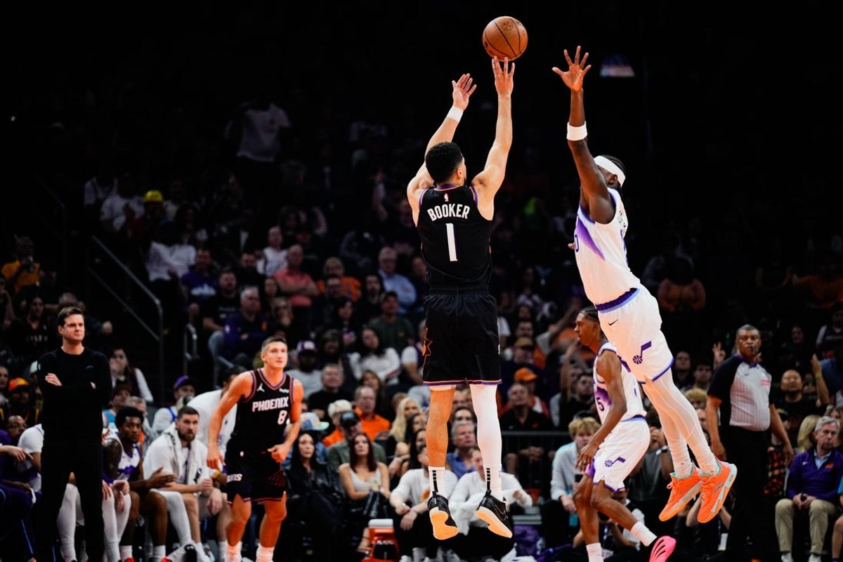 Oct 31, 2025; Phoenix, Arizona, USA;  Phoenix Suns guard Devin Booker (1) shoots a three-point shot in the first half between the Phoenix Suns and the Utah Jazz at Mortgage Matchup Center. Mandatory Credit: Arianna Grainey-Imagn Images