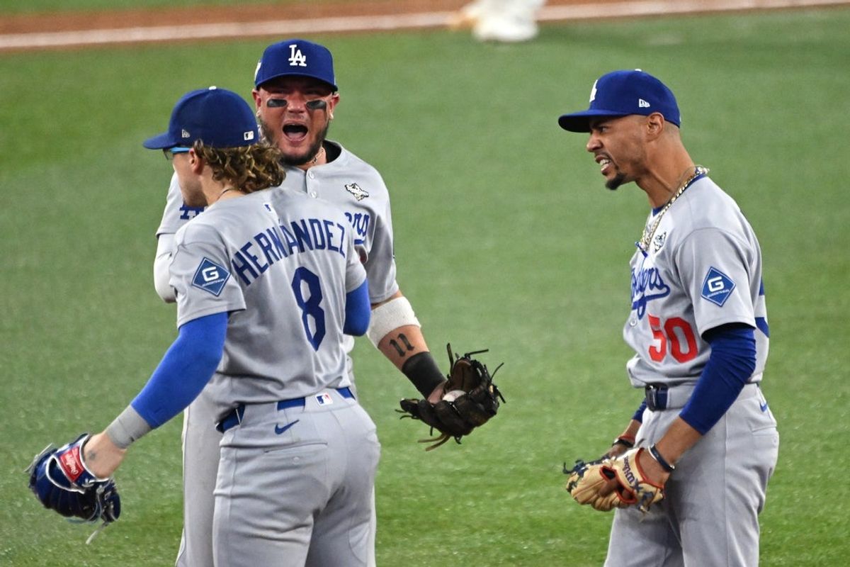 Oct 31, 2025; Toronto, Ontario, CAN; Los Angeles Dodgers first baseman Enrique Hernandez (8) and second baseman Miguel Rojas (72) and shortstop Mookie Betts (50) celebrate after defeating the Toronto Blue Jays in game six of the 2025 MLB World Series at Rogers Centre. Mandatory Credit: Dan Hamilton-Imagn Images