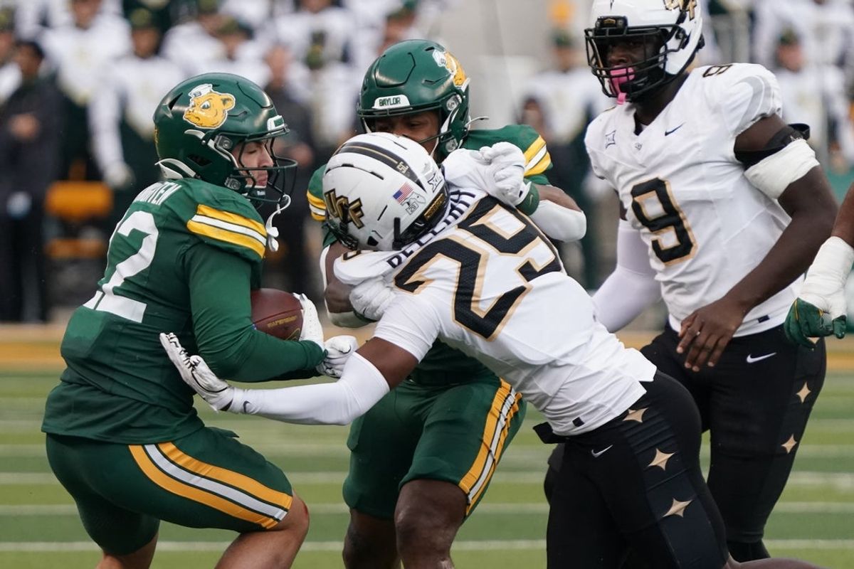 Nov 1, 2025; Waco, Texas, USA; Baylor Bears running back Caden Knighten (22) carries the ball as UCF Knights cornerback Jayden Bellamy (29) defends during the first half at McLane Stadium. Mandatory Credit: Raymond Carlin III-Imagn Images