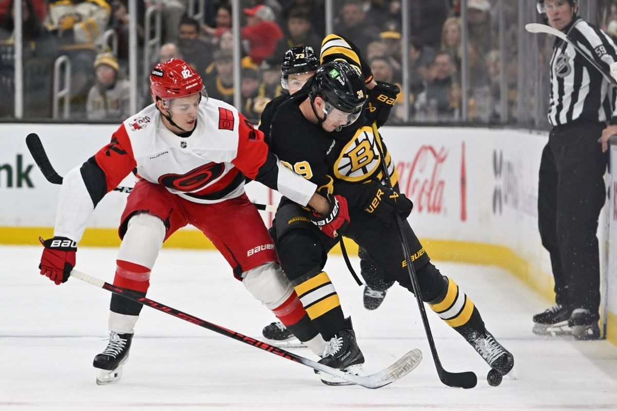Nov 1, 2025; Boston, Massachusetts, USA; Boston Bruins center Morgan Geekie (39) and Carolina Hurricanes center Jesperi Kotkaniemi (82) battle for control of the puck during the second period at TD Garden. Mandatory Credit: Eric Canha-Imagn Images