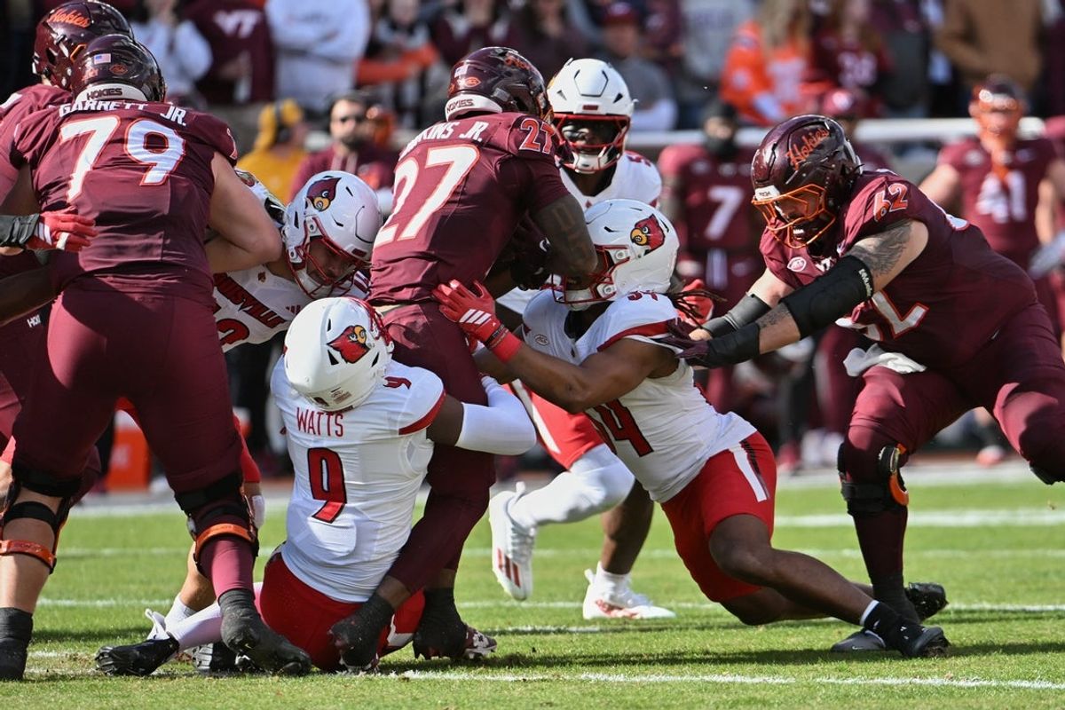Nov 1, 2025; Blacksburg, Virginia, USA;  Louisville Cardinals defensive back Antonio Watts (9) tackles Virginia Tech Hokies running back Marcellous Hawkins (27) during the first quarter at Lane Stadium. Mandatory Credit: Brian Bishop-Imagn Images