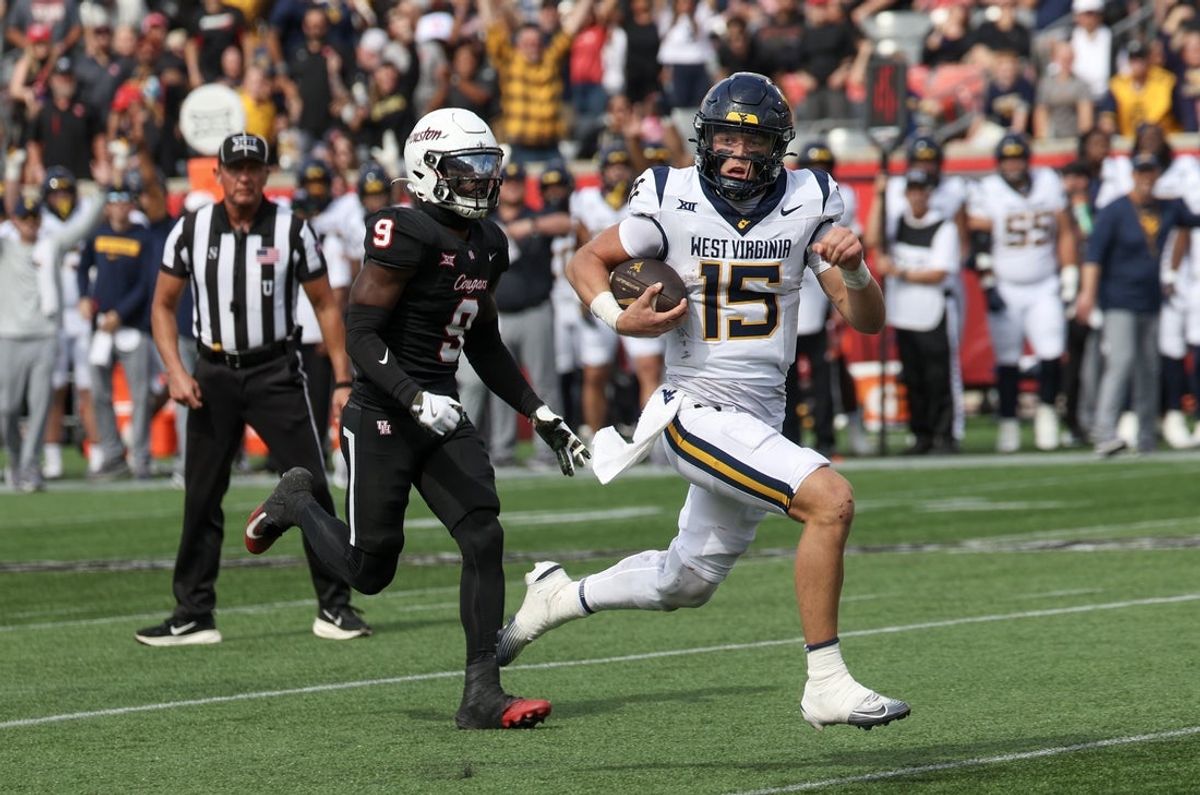 Nov 1, 2025; Houston, Texas, USA; West Virginia Mountaineers quarterback Scotty Fox Jr. (15) rushes for a touchdown against tHouston Cougars linebacker Corey Platt Jr. (9)  in the second half at TDECU Stadium. Mandatory Credit: Thomas Shea-Imagn Images