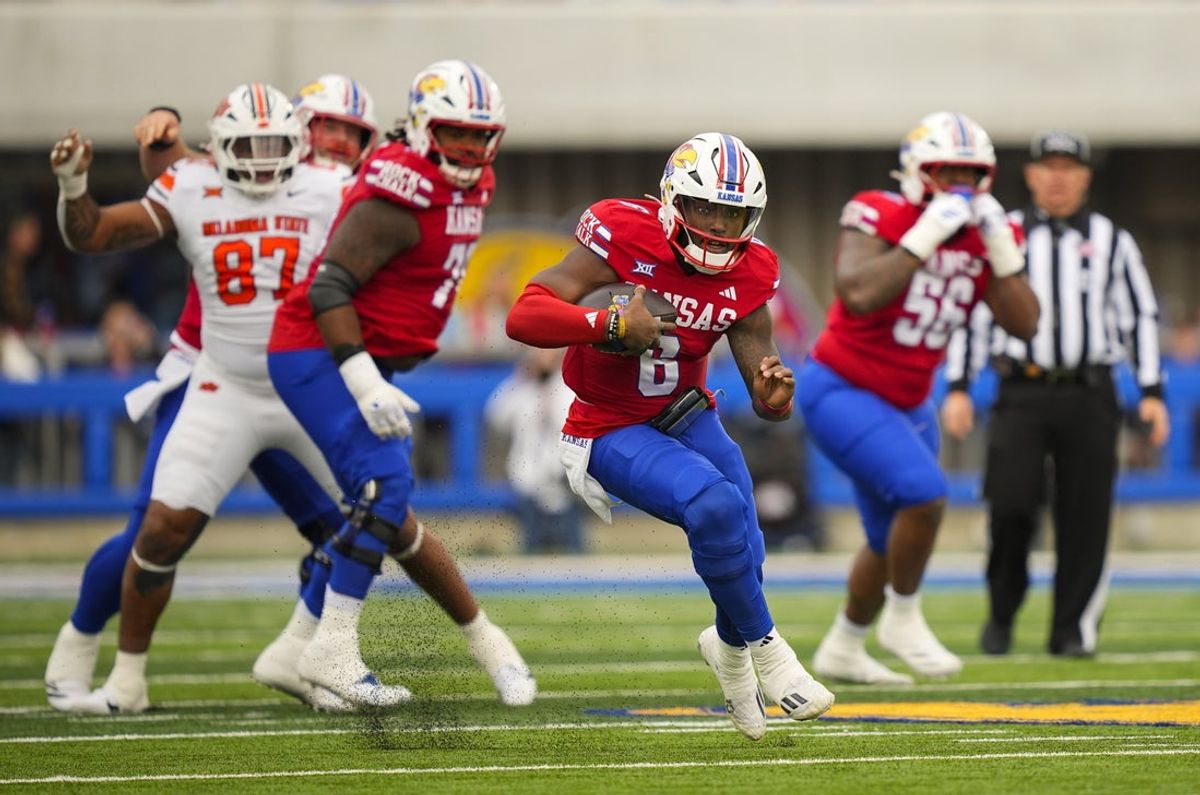 Nov 1, 2025; Lawrence, Kansas, USA; Kansas Jayhawks quarterback Jalon Daniels (6) runs the ball during the first half against the Oklahoma State Cowboys at David Booth Kansas Memorial Stadium. Mandatory Credit: Jay Biggerstaff-Imagn Images