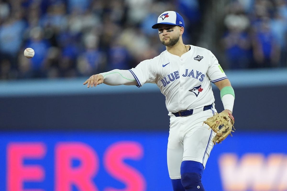 Nov 1, 2025; Toronto, Ontario, CAN; Toronto Blue Jays designated hitter Bo Bichette (11) throws to first for an out against Los Angeles Dodgers second baseman Tommy Edman (25) in the eighth inning during game seven of the 2025 MLB World Series at Rogers Centre. Mandatory Credit: John E. Sokolowski-Imagn Images