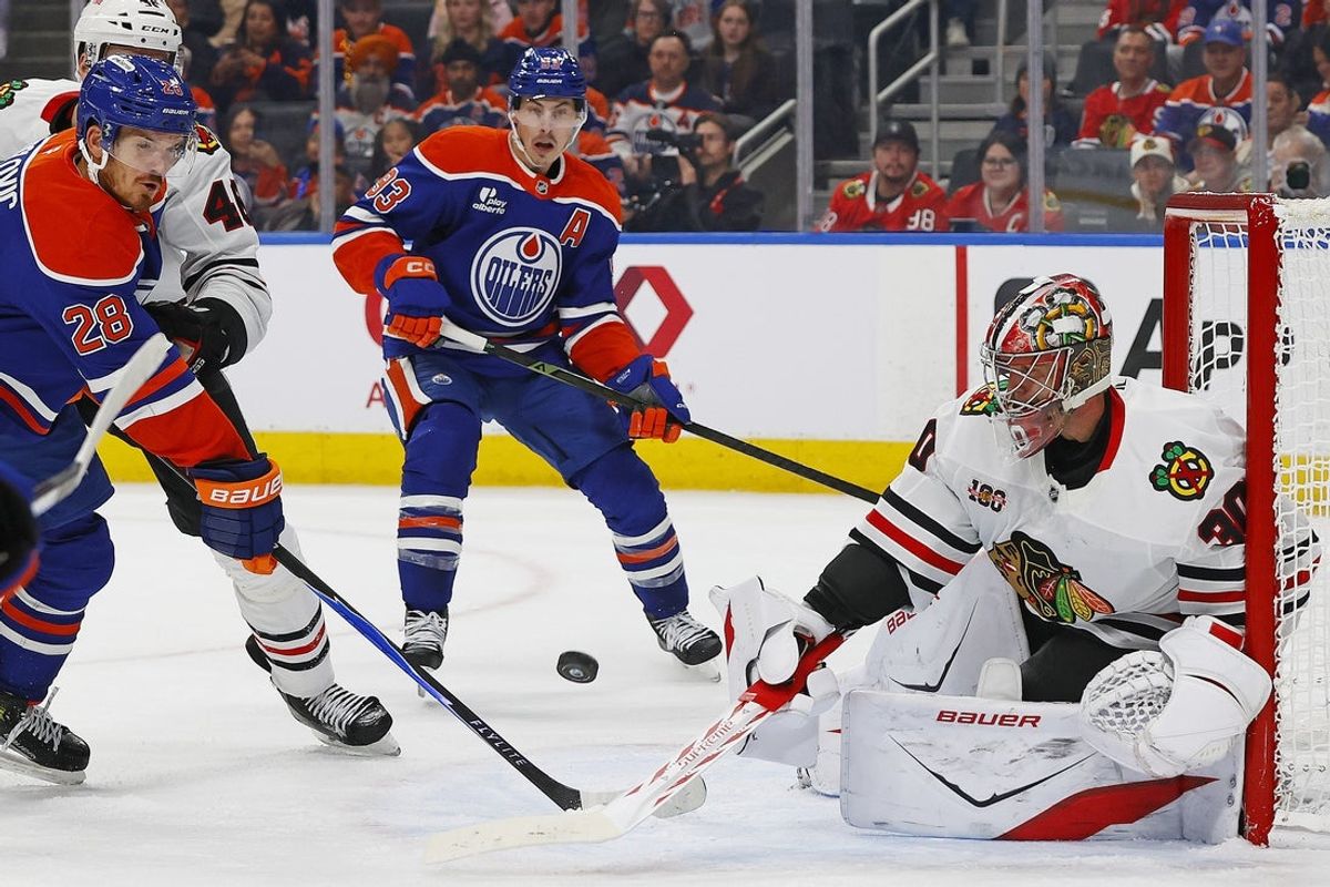 Nov 1, 2025; Edmonton, Alberta, CAN; Edmonton Oilers forward Jack Roslovic (28) and forward Ryan Nugent-Hopkins (93) look for a deflection in front of Chicago Blackhawks goaltender Spencer Knight (30) during the first period at Rogers Place. Mandatory Credit: Perry Nelson-Imagn Images