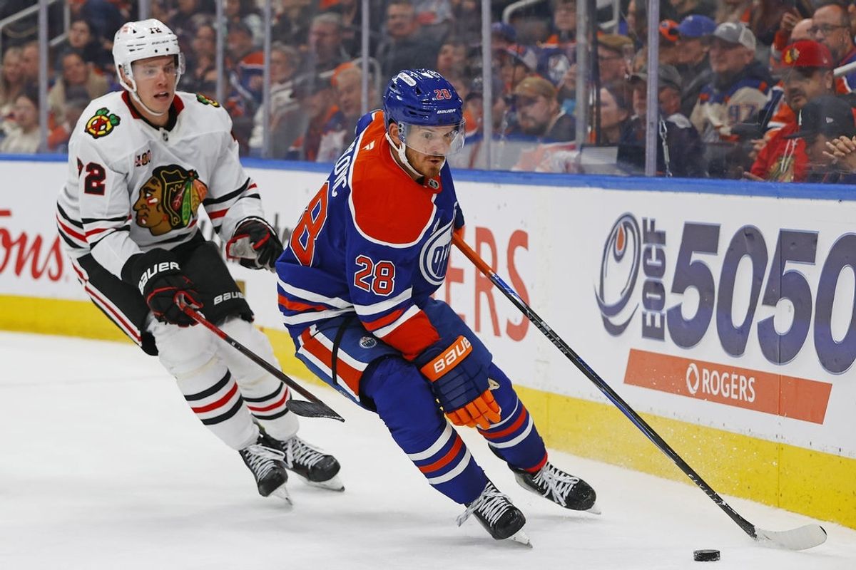 Nov 1, 2025; Edmonton, Alberta, CAN; Edmonton Oilers forward Jack Roslovic (28) protects the puck from Chicago Blackhawks defensemen Alex Vlasic (72) during the third period at Rogers Place. Mandatory Credit: Perry Nelson-Imagn Images