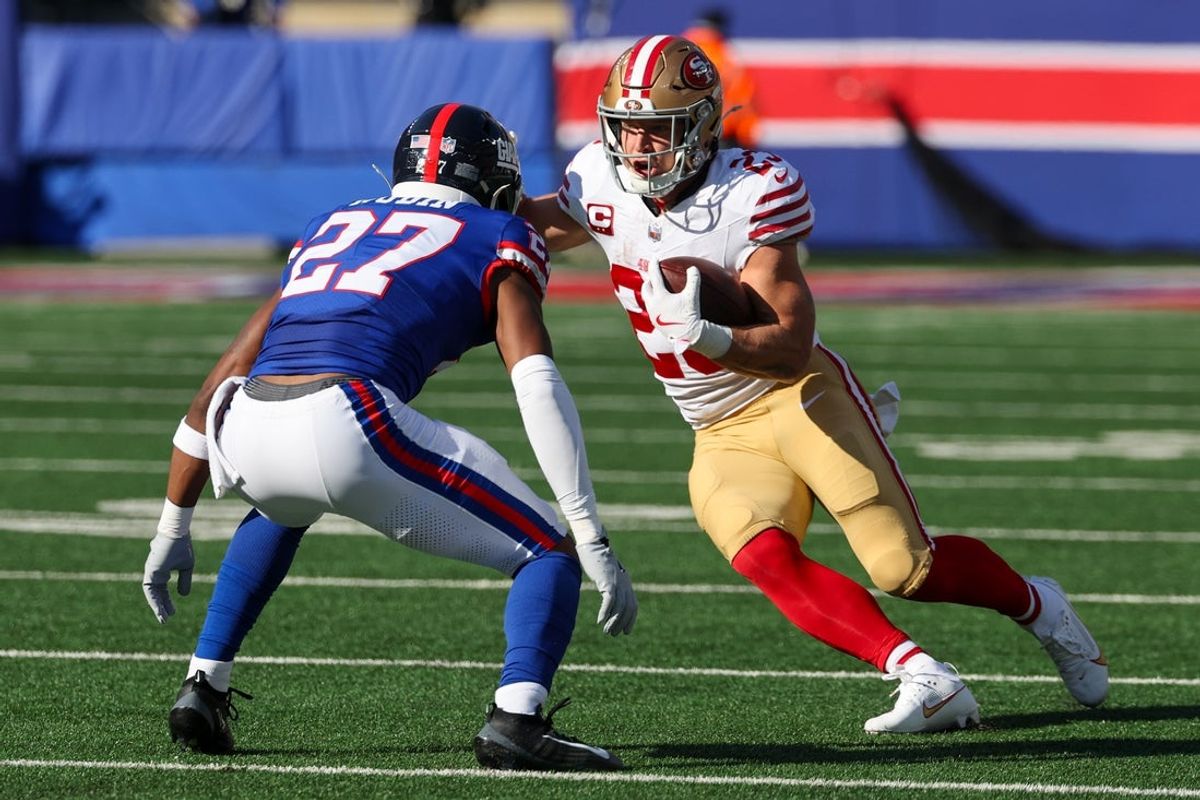 Nov 2, 2025; East Rutherford, New Jersey, USA; San Francisco 49ers running back Christian McCaffrey (23) carries the ball as New York Giants safety Tyler Nubin (27) defends during the first half at MetLife Stadium. Mandatory Credit: Ed Mulholland-Imagn Images