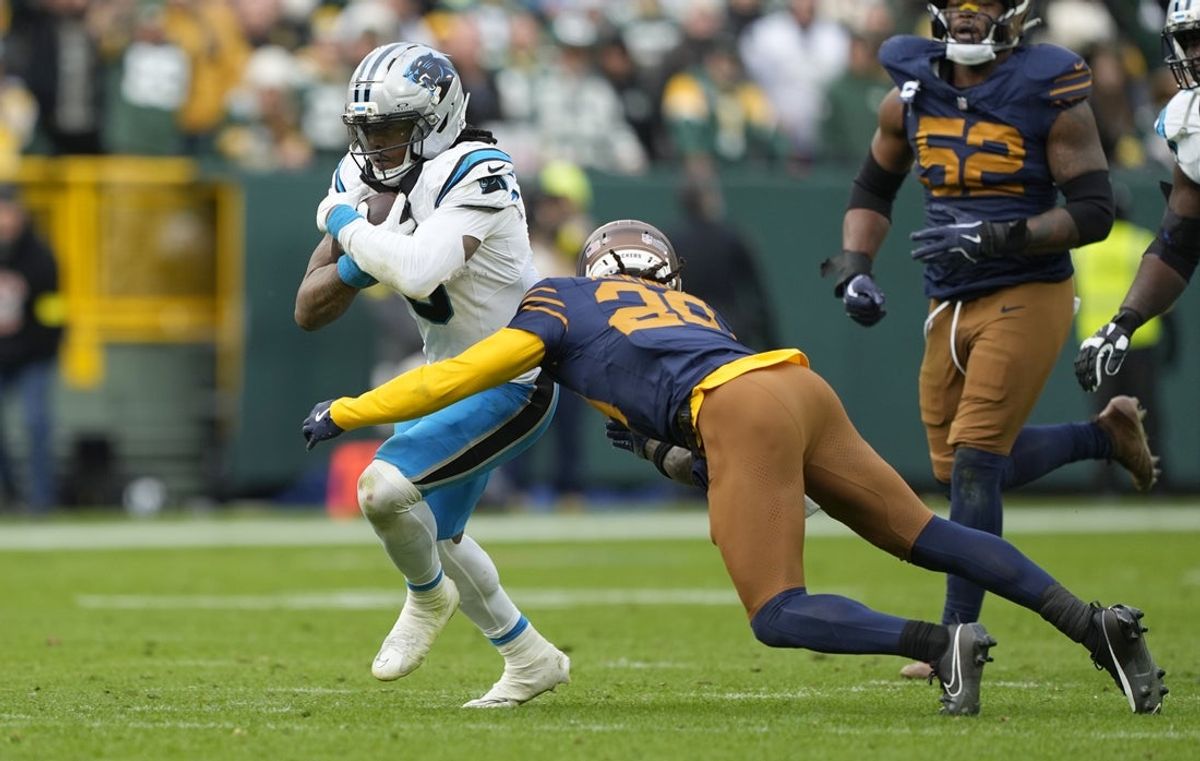 Nov 2, 2025; Green Bay, Wisconsin, USA; Carolina Panthers running back Rico Dowdle (5) runs against Green Bay Packers safety Xavier McKinney (29) during the second half at Lambeau Field. Mandatory Credit: Jeff Hanisch-Imagn Images