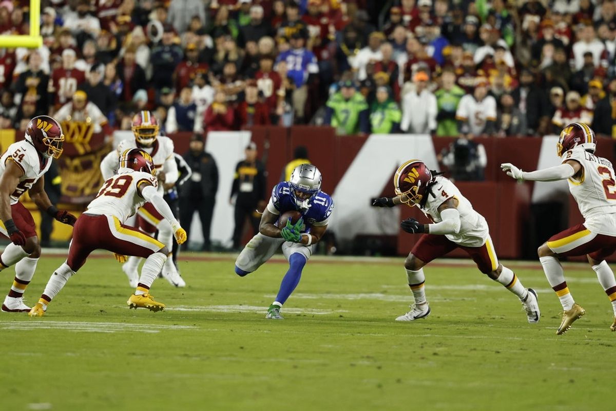 Nov 2, 2025; Landover, Maryland, USA;  Seattle Seahawks wide receiver Jaxon Smith-Njigba (11) runs with ball after making a catch defended by Washington Commanders linebacker Frankie Luvu (4) during the first quarter at Northwest Stadium. Mandatory Credit: Geoff Burke-Imagn Images