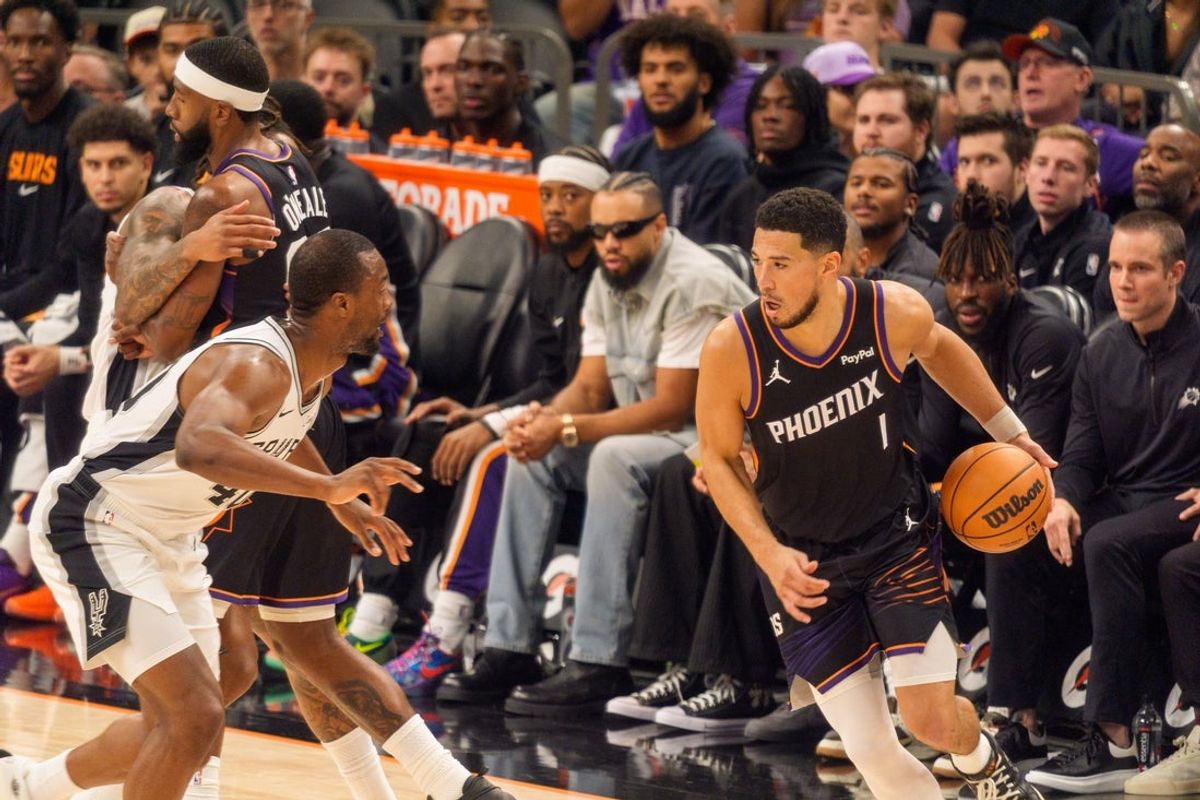 Nov 2, 2025; Phoenix, Arizona, USA; Phoenix Suns guard Devin Booker (1) drives against San Antonio Spurs forward Harrison Barnes (40) during the first half at PHX Arena. Mandatory Credit: Allan Henry-Imagn Images