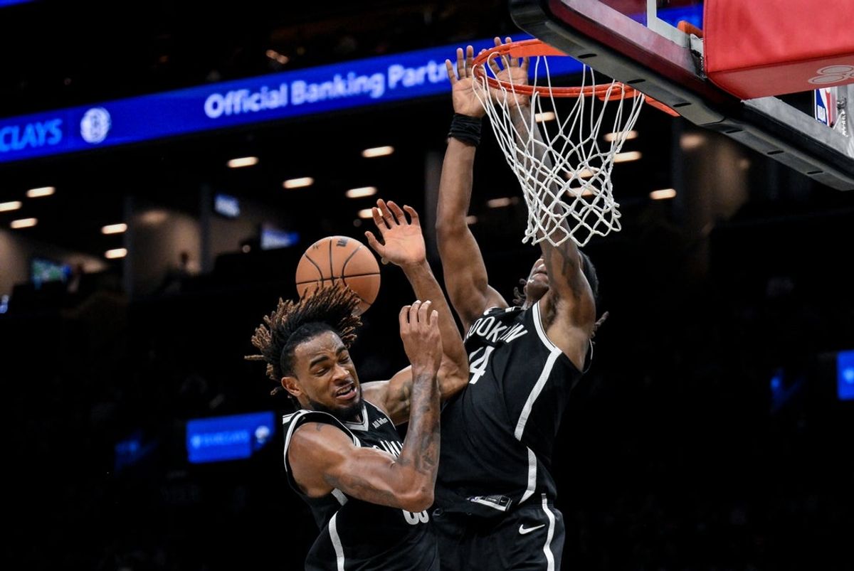 Nov 2, 2025; Brooklyn, New York, USA; Brooklyn Nets center Nic Claxton (33) and guard Terance Mann (14) collide while pursuing a lop pass during the second half against the Philadelphia 76ers at Barclays Center. Mandatory Credit: John Jones-Imagn Images