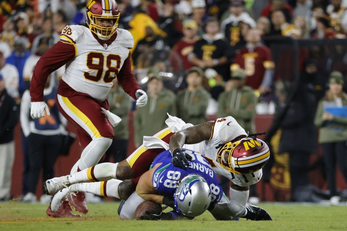 Nov 2, 2025; Landover, Maryland, USA; Washington Commanders linebacker Frankie Luvu (4) tackles Seattle Seahawks tight end AJ Barner (88) during the first half at Northwest Stadium. Mandatory Credit: Amber Searls-Imagn Images