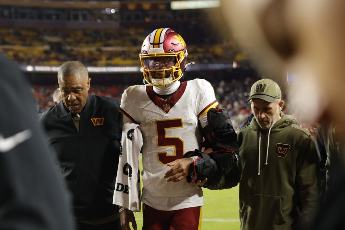 Nov 2, 2025; Landover, Maryland, USA; Washington Commanders quarterback Jayden Daniels (5) is helped off the field after an injury during the second half against the Seattle Seahawks at Northwest Stadium. Mandatory Credit: Amber Searls-Imagn Images