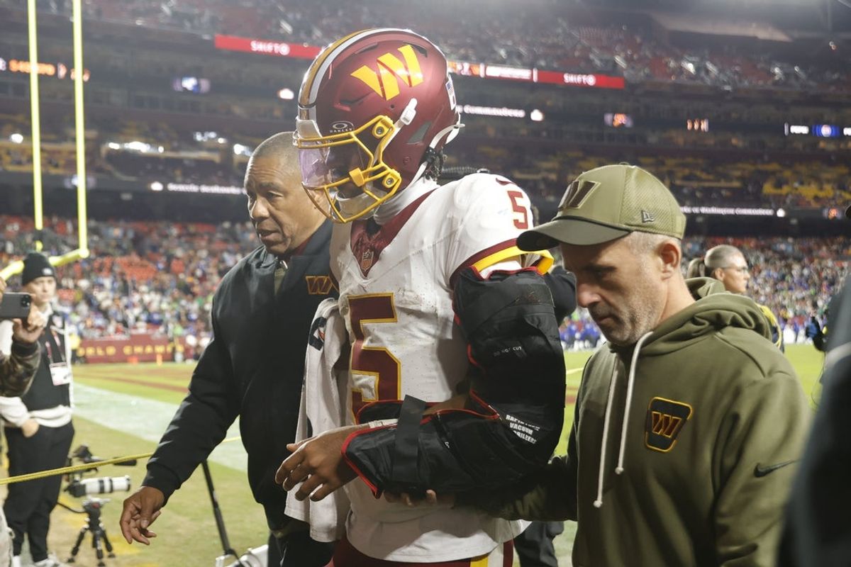 Nov 2, 2025; Landover, Maryland, USA; Washington Commanders quarterback Jayden Daniels (5) is helped off the field after an injury during the second half against the Seattle Seahawks at Northwest Stadium. Mandatory Credit: Amber Searls-Imagn Images