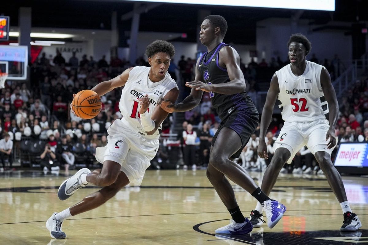 Nov 3, 2025; Cincinnati, Ohio, USA;  Cincinnati Bearcats forward Baba Miller (18) drives to the basket against Western Carolina Catamounts forward Samuel Dada (12) in the first half at Fifth Third Arena. Mandatory Credit: Aaron Doster-Imagn Images