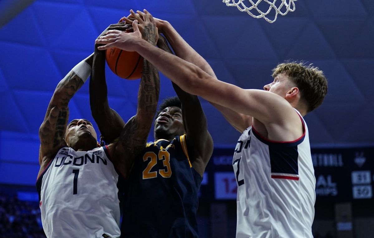 Nov 3, 2025; Storrs, Connecticut, USA; UConn Huskies guard Solo Ball (1) and center Eric Reibe (12) defend against New Haven Chargers guard Najimi George (23) in the first half at Harry A. Gampel Pavilion. Mandatory Credit: David Butler II-Imagn Images