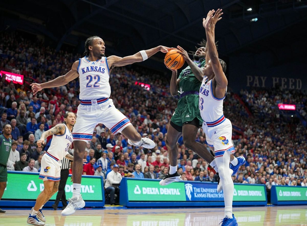 Nov 3, 2025; Lawrence, Kansas, USA; Green Bay Phoenix guard C.J. O'Hara (10) shoots against Kansas Jayhawks guard Darryn Peterson (22) and guard Elmarko Jackson (13) during the first half at Allen Fieldhouse. Mandatory Credit: Jay Biggerstaff-Imagn Images