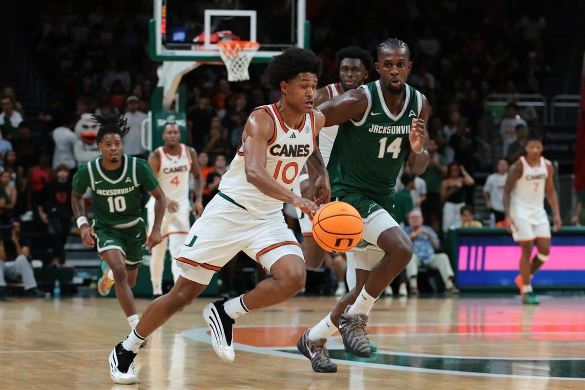 Nov 3, 2025; Coral Gables, Florida, USA; Miami Hurricanes guard Tru Washington (10) drives to the basket against Jacksonville Dolphins forward Allen Udemadu (14) during the first half at Watsco Center. Mandatory Credit: Sam Navarro-Imagn Images