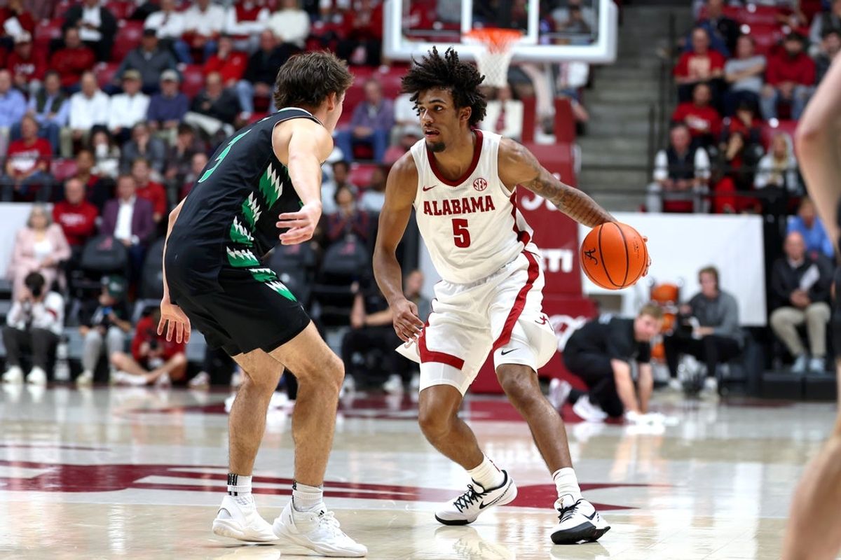 Nov 3, 2025; Tuscaloosa, Alabama, USA; Alabama Crimson Tide forward Amari Allen (5) dribbles against North Dakota Fighting Hawks guard Greyson Uelmen (3) during the first half at Coleman Coliseum. Mandatory Credit: David Leong-Imagn Images