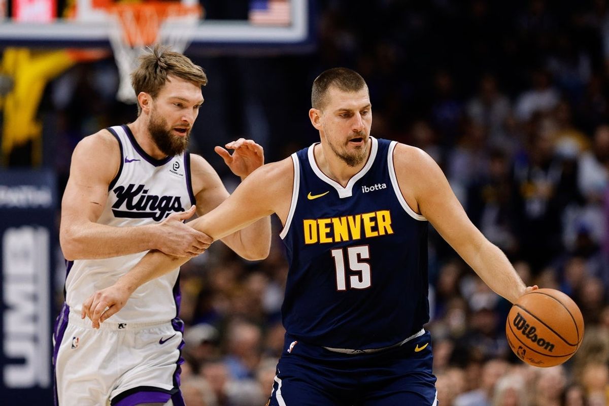 Nov 3, 2025; Denver, Colorado, USA; Denver Nuggets center Nikola Jokic (15) dribbles the ball up court as Sacramento Kings forward Domantas Sabonis (11) defends in the first quarter at Ball Arena. Mandatory Credit: Isaiah J. Downing-Imagn Images