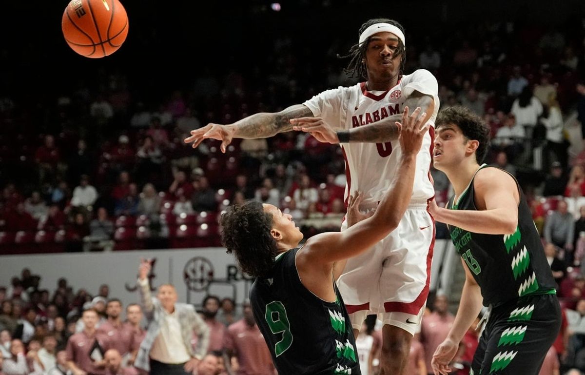 Nov 3, 2025; Tuscaloosa, Alabama, USA; Alabama guard Labaron Philon Jr. (0) makes a pass over North Dakota guard Anthony Smith III (9) during the season-opening game at Coleman Coliseum.