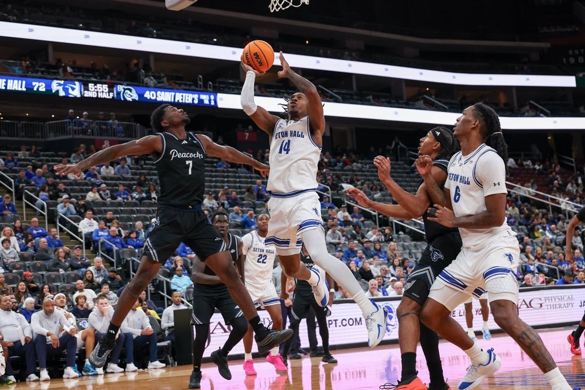 Nov 3, 2025; Newark, New Jersey, USA; Seton Hall Pirates guard A.J. Staton-Mccray (14) goes to the basket against Saint Peter's Peacocks guard Elijah Perkins (7) during the second half at Prudential Center. Mandatory Credit: Vincent Carchietta-Imagn Images