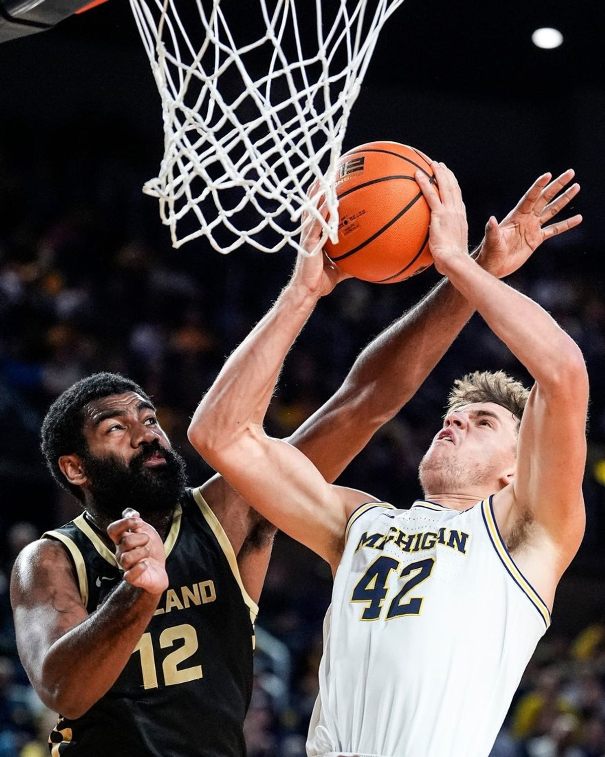 Michigan forward Will Tschetter (42) goes to the basket against Oakland forward Tuburu Naivalurua (12) during the first half at Crisler Center in Ann Arbor on Monday, November 3, 2025.
