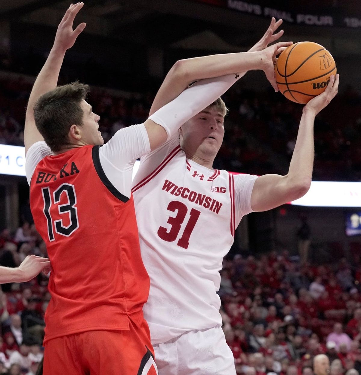 Wisconsin forward Nolan Winter (31) beats Campbell forward Dovydas Butka (13) to a rebound during the first half of their game Monday, November 3, 2025 at the Kohl Center in Madison, Wisconsin.
