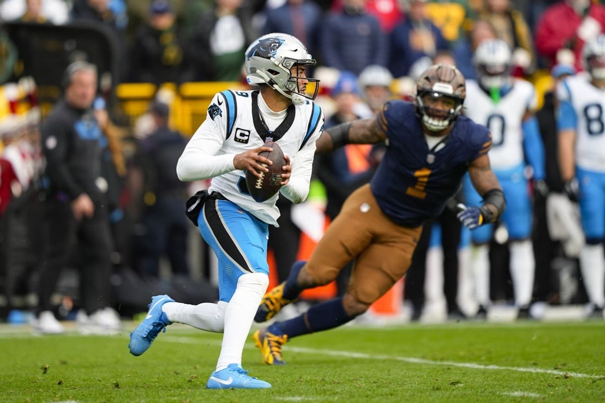 Nov 2, 2025; Green Bay, Wisconsin, USA;  Carolina Panthers quarterback Bryce Young (9) is chased by Green Bay Packers defensive end Micah Parsons (1) during the game at Lambeau Field. Mandatory Credit: Jeff Hanisch-Imagn Images
