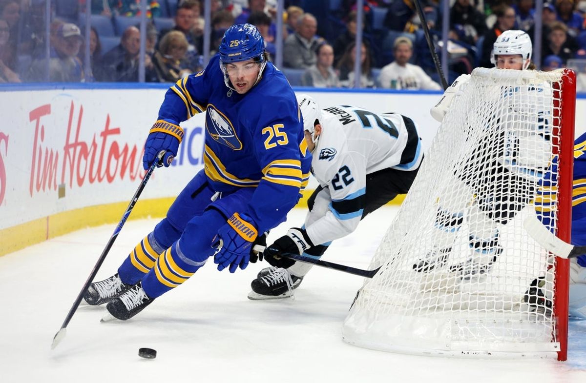 Nov 4, 2025; Buffalo, New York, USA;  Buffalo Sabres defenseman Owen Power (25) controls the puck behind the net as Utah Mammoth center Jack McBain (22) defends during the first period at KeyBank Center. Mandatory Credit: Timothy T. Ludwig-Imagn Images