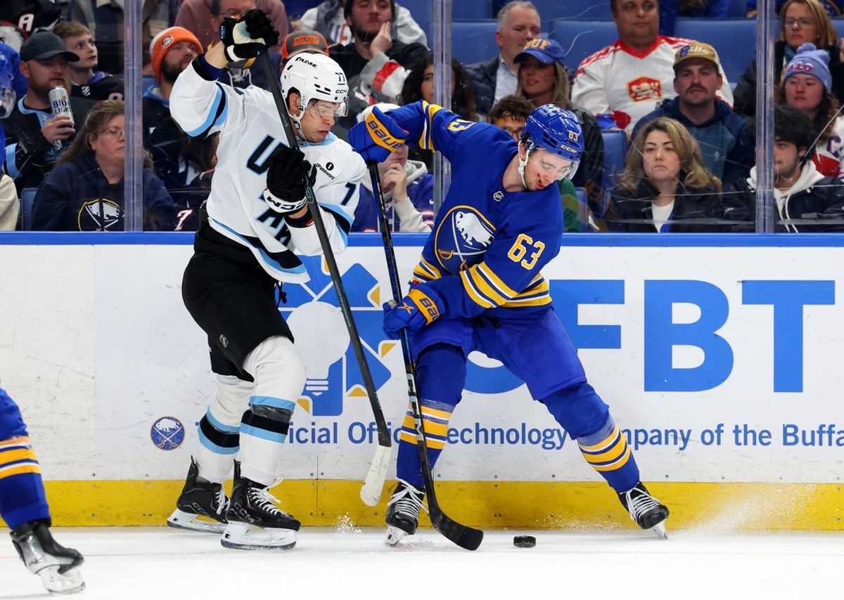 Nov 4, 2025; Buffalo, New York, USA;  Utah Mammoth right wing JJ Peterka (77) and Buffalo Sabres right wing Isak Rosen (63) go after a loose puck during the third period at KeyBank Center. Mandatory Credit: Timothy T. Ludwig-Imagn Images