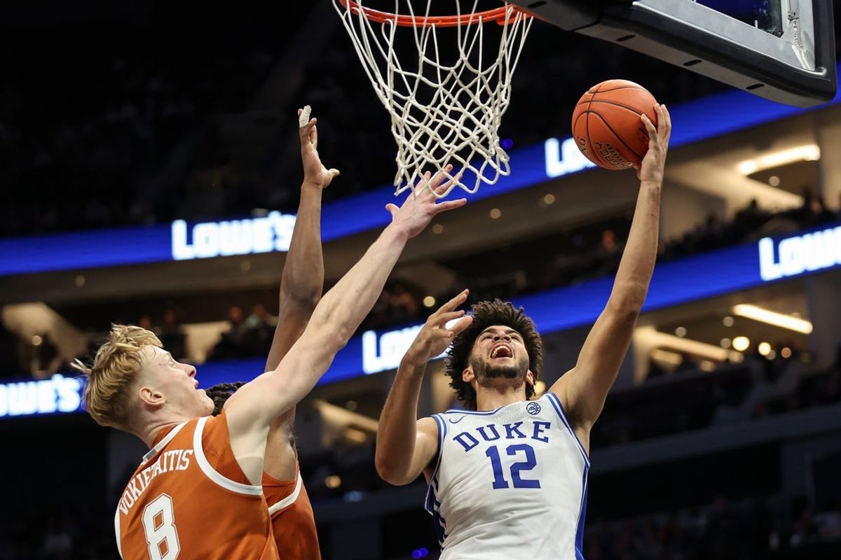Nov 4, 2025; Charlotte, North Carolina, USA; Duke Blue Devils forward Cameron Boozer (12) goes for a lay up against the Texas Longhorns during the first half of the Dick Vitale’s Invitational game at Spectrum Center. Mandatory Credit: Cory Knowlton-Imagn Images