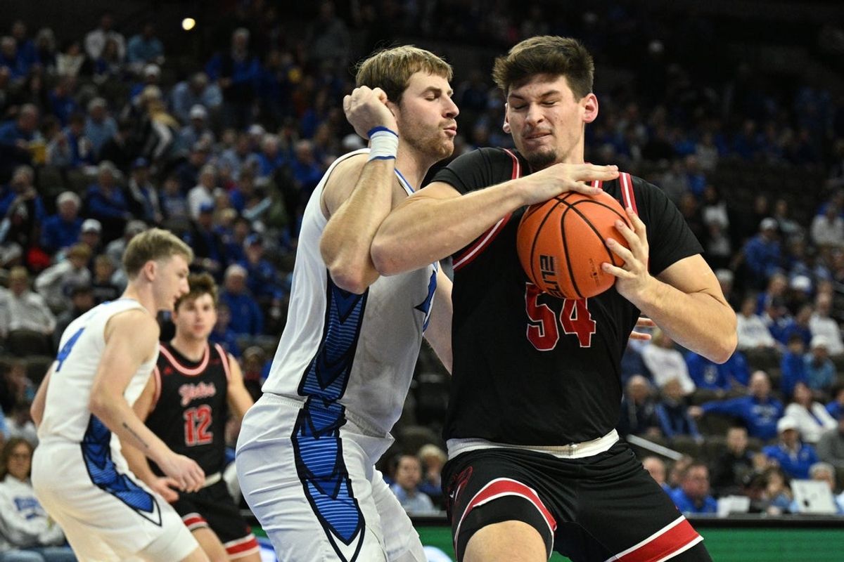 Nov 5, 2025; Omaha, Nebraska, USA;  South Dakota Coyotes center Cameron Fens (54) drives against Creighton Bluejays forward Isaac Traudt (41) during the first half at CHI Health Center Omaha. Mandatory Credit: Steven Branscombe-Imagn Images