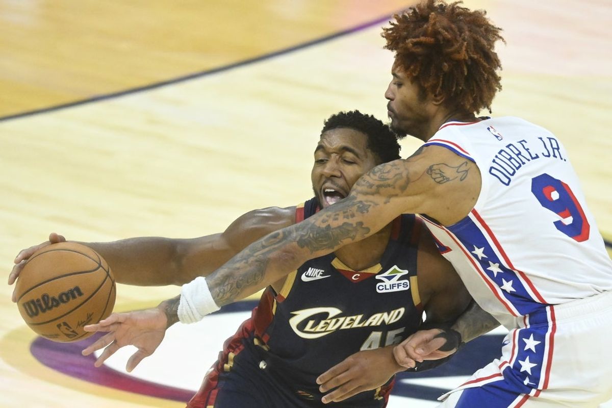 Nov 5, 2025; Cleveland, Ohio, USA; Cleveland Cavaliers guard Donovan Mitchell (45) dribbles against Philadelphia 76ers guard Kelly Oubre Jr. (9) in the third quarter at Rocket Arena. Mandatory Credit: David Richard-Imagn Images