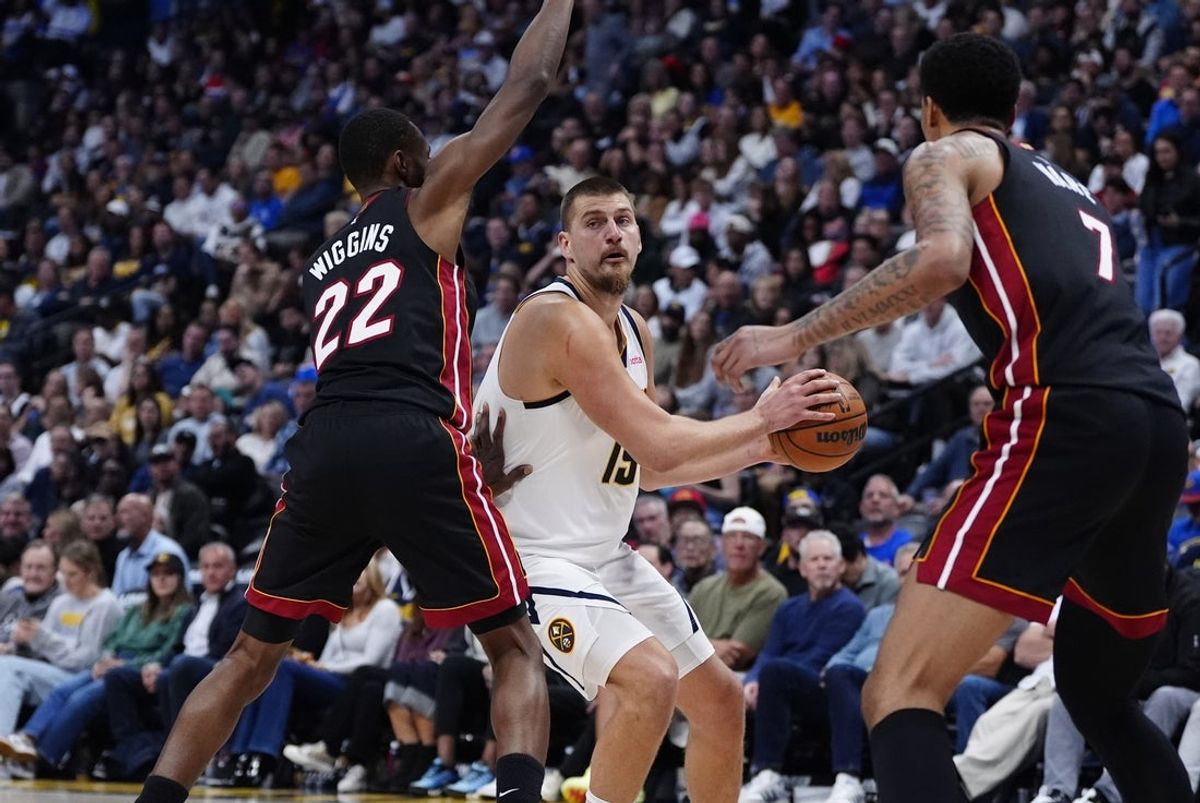 Nov 5, 2025; Denver, Colorado, USA; Miami Heat forward Andrew Wiggins (22) and center Kel'el Ware (7) defend on Denver Nuggets center Nikola Jokic (15) in the second quarter at Ball Arena. Mandatory Credit: Ron Chenoy-Imagn Images