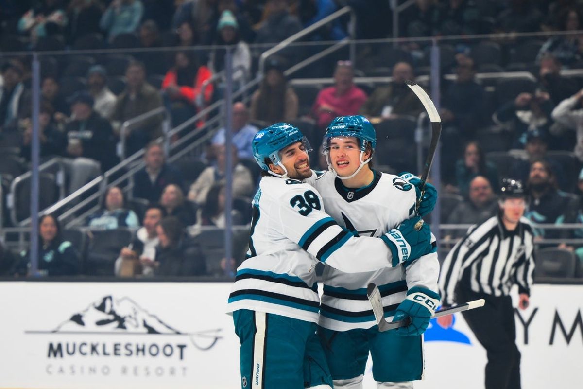 Nov 5, 2025; Seattle, Washington, USA; San Jose Sharks defenseman Mario Ferraro (38) and center Macklin Celebrini (71) celebrate after Celebrini scored a goal against the Seattle Kraken during the first period at Climate Pledge Arena. Mandatory Credit: Steven Bisig-Imagn Images