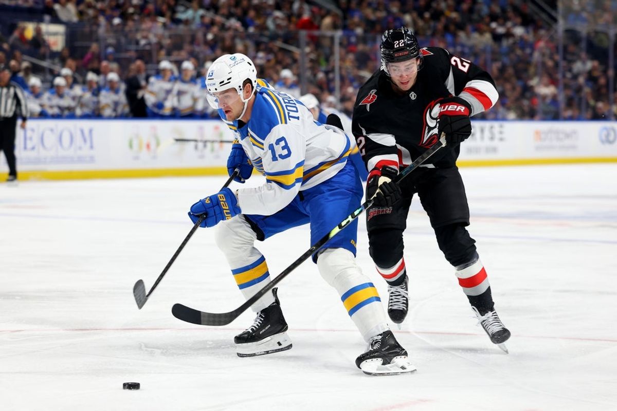 Nov 6, 2025; Buffalo, New York, USA;  St. Louis Blues right wing Alexey Toropchenko (13) goes after the puck as Buffalo Sabres right wing Jack Quinn (22) defends during the first period at KeyBank Center. Mandatory Credit: Timothy T. Ludwig-Imagn Images