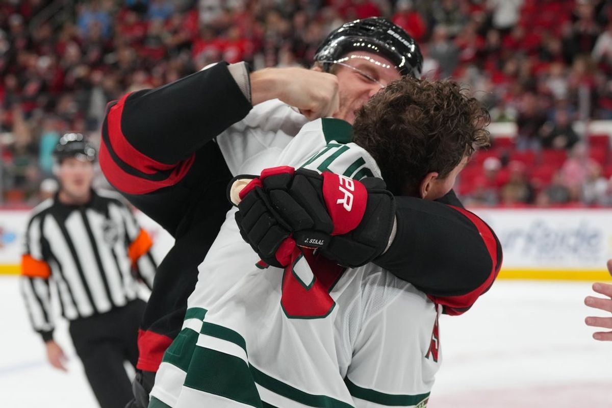 Nov 6, 2025; Raleigh, North Carolina, USA;  Carolina Hurricanes center Jordan Staal (11) fights Minnesota Wild center Tyler Pitlick (19) during the first period at Lenovo Center. Mandatory Credit: James Guillory-Imagn Images