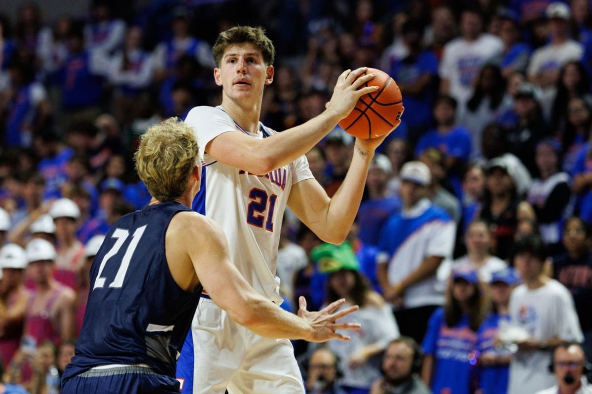 Nov 6, 2025; Gainesville, Florida, USA; Florida Gators forward Alex Condon (21) looks to pass over North Florida Ospreys forward Dalton Gayman (21) during the second half at Exactech Arena at the Stephen C. O'Connell Center. Mandatory Credit: Matt Pendleton-Imagn Images