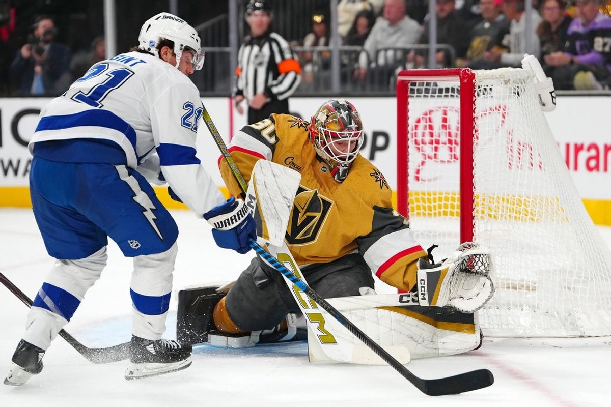 Nov 6, 2025; Las Vegas, Nevada, USA; Vegas Golden Knights goaltender Carl Lindbom (30) defends his net against Tampa Bay Lightning center Brayden Point (21) during the first period at T-Mobile Arena. Mandatory Credit: Stephen R. Sylvanie-Imagn Images