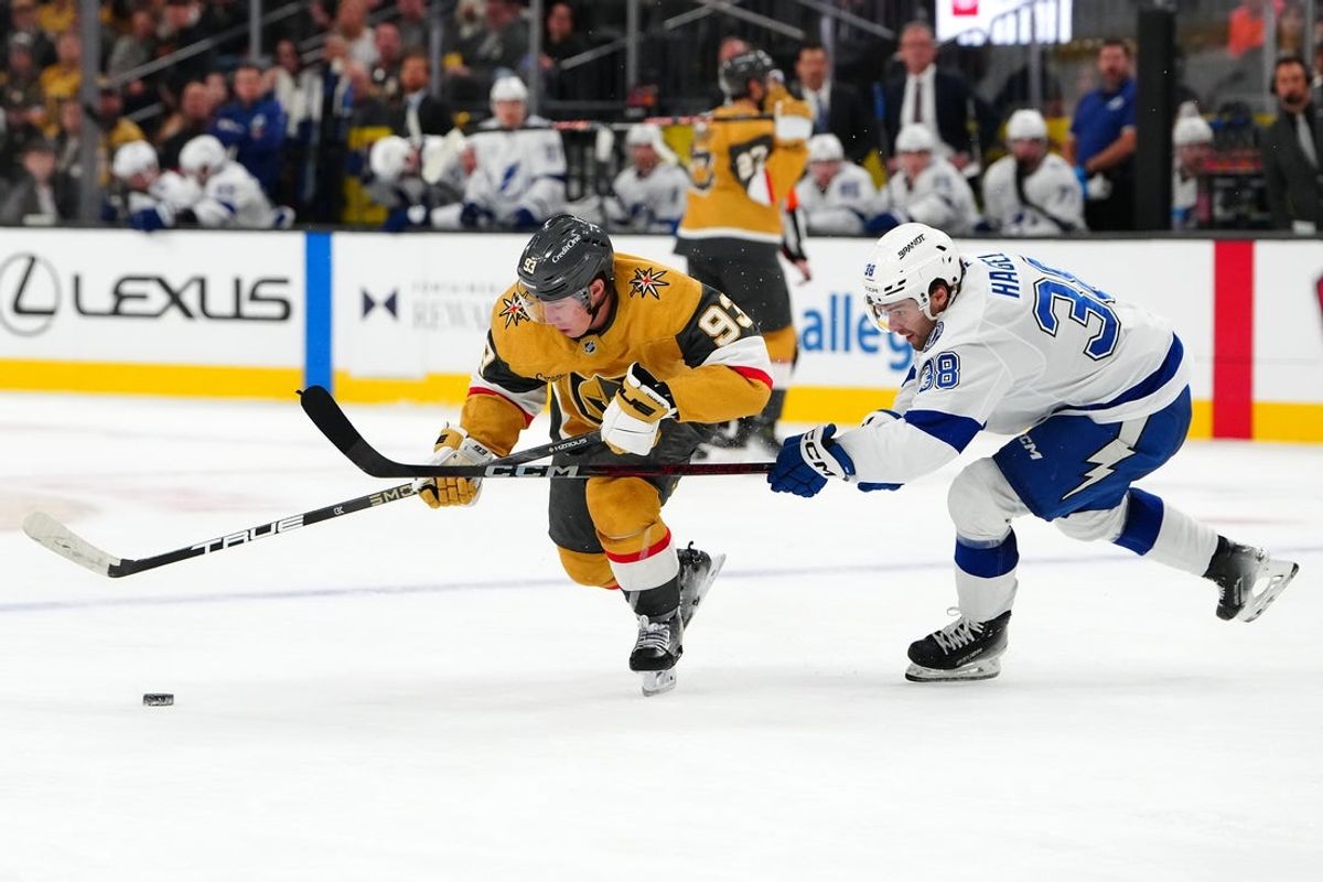 Nov 6, 2025; Las Vegas, Nevada, USA; Vegas Golden Knights right wing Mitch Marner (93) skates through the stick check of Tampa Bay Lightning left wing Brandon Hagel (38) during the second period at T-Mobile Arena. Mandatory Credit: Stephen R. Sylvanie-Imagn Images