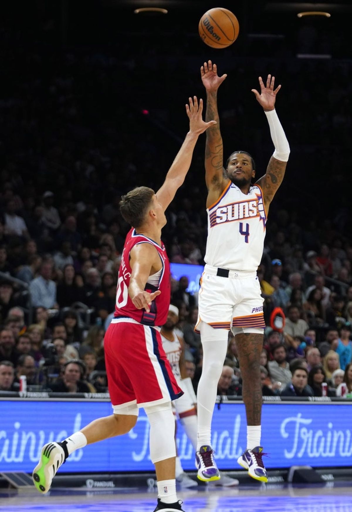 Suns guard Jalen Green (4) makes a three pointer against Clippers guard Bogdan Bogdanovic during a game at the Mortgage Matchup Center on Nov. 6, 2025.