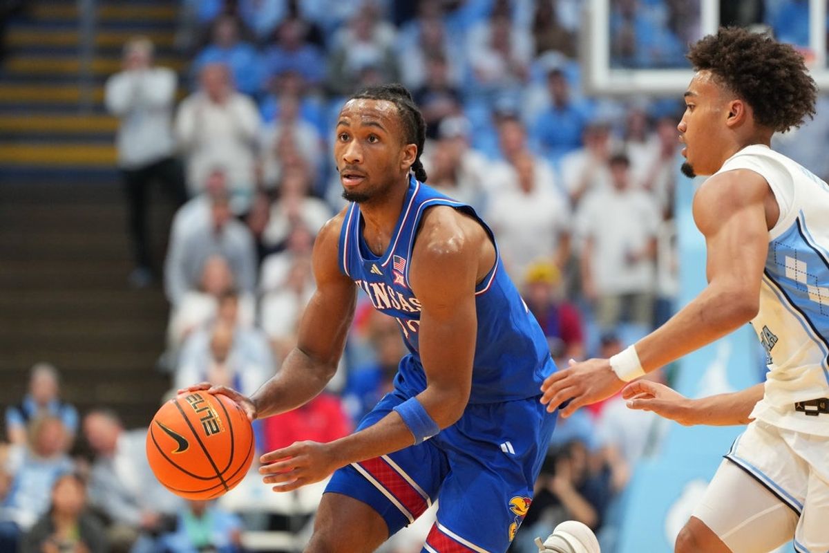 Nov 7, 2025; Chapel Hill, North Carolina, USA; Kansas Jayhawks guard Darryn Peterson (22) dribbles as North Carolina Tar Heels guard Seth Trimble (7) defends in the first half at Dean E. Smith Center. Mandatory Credit: Bob Donnan-Imagn Images