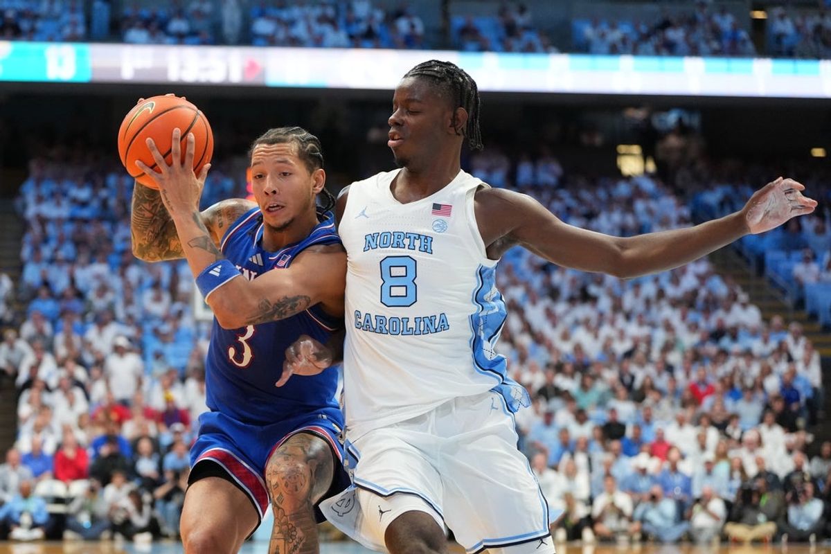 Nov 7, 2025; Chapel Hill, North Carolina, USA;  Kansas Jayhawks guard Tre White (3) with the ball as North Carolina Tar Heels forward Caleb Wilson (8) defends in the first half at Dean E. Smith Center. Mandatory Credit: Bob Donnan-Imagn Images