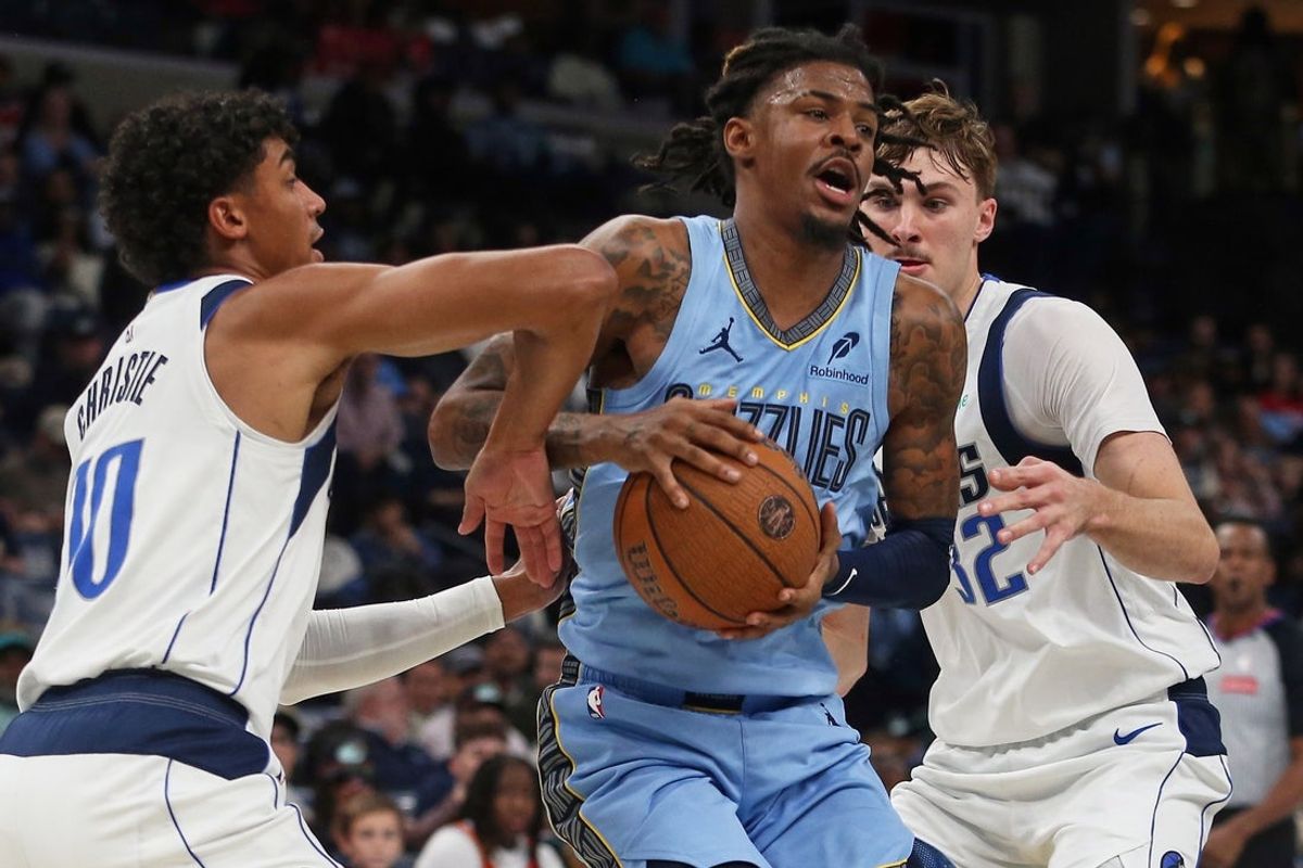 Nov 7, 2025; Memphis, Tennessee, USA; Memphis Grizzlies guard Ja Morant (12) drives to the basket against Dallas Mavericks guard Max Christie (00) and forward Cooper Flagg (32) during the second quarter at FedExForum. Mandatory Credit: Petre Thomas-Imagn Images